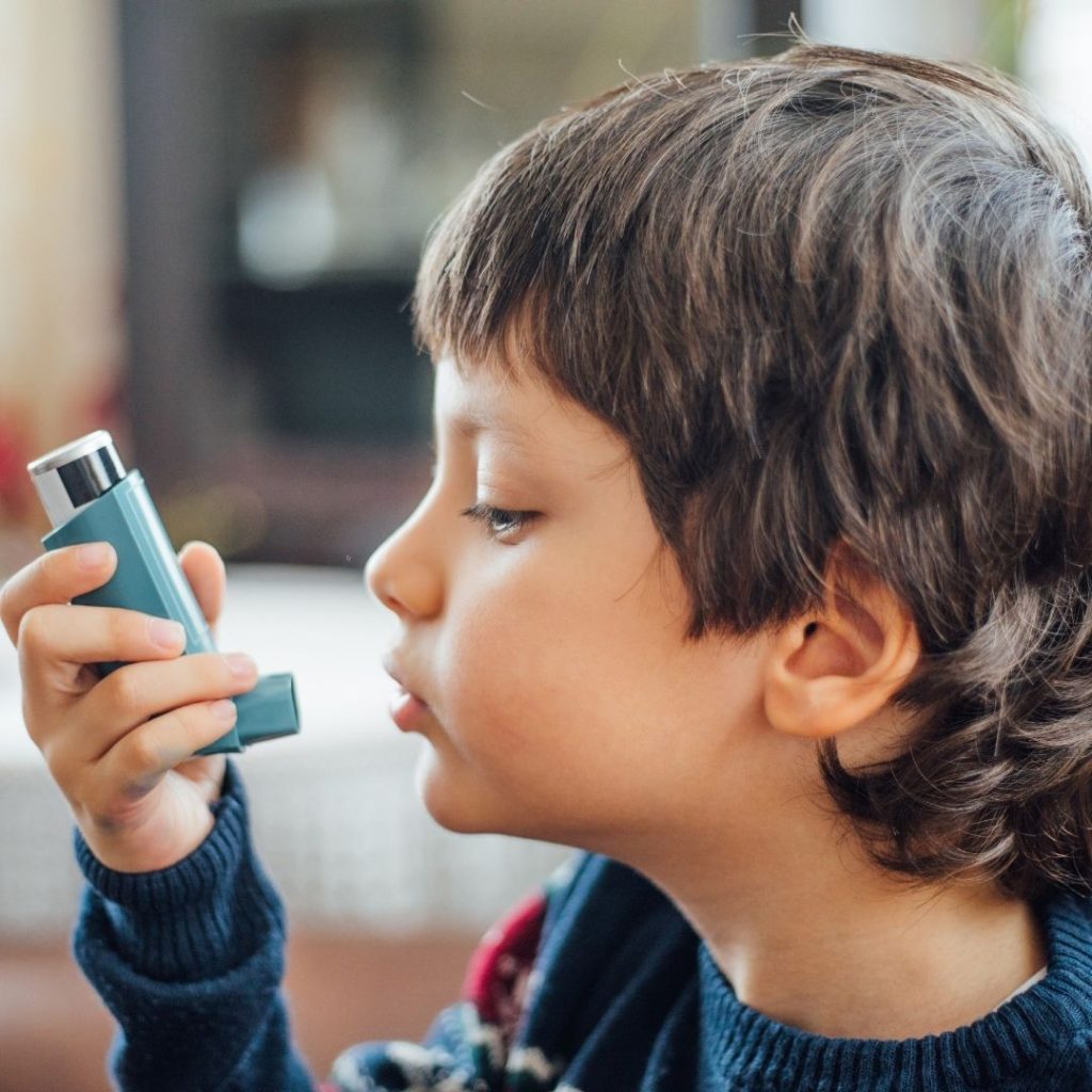 Child using a blue inhaler